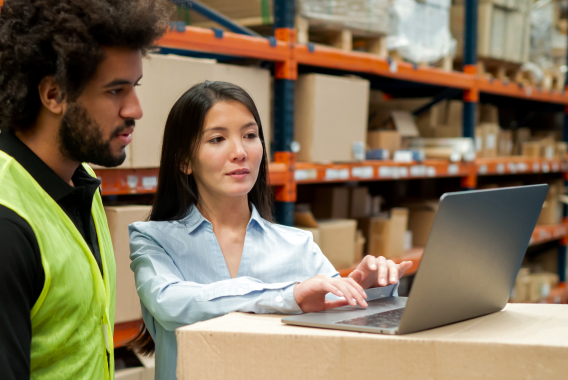 Woman and a man looking at a laptop in a warehouse